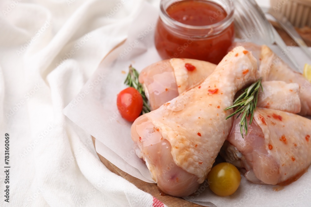 Marinade, raw chicken drumsticks, rosemary and tomatoes on table, closeup. Space for text Marinade, raw chicken drumsticks, rosemary and tomatoes on table, closeup. Space for text