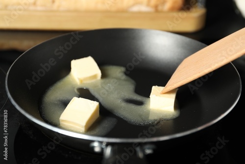 Foto Stirring melting butter in frying pan on table, closeup