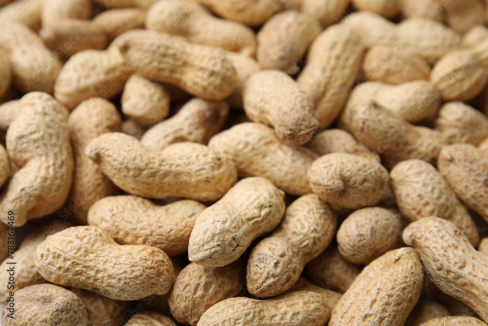 Many fresh unpeeled peanuts as background, closeup Many fresh unpeeled peanuts as background, closeup