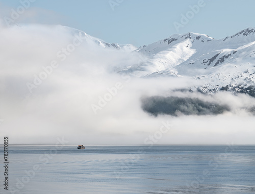 Boat approaching fog on the mountains and sea in Passage Canal, Whittier, Alaska USA
