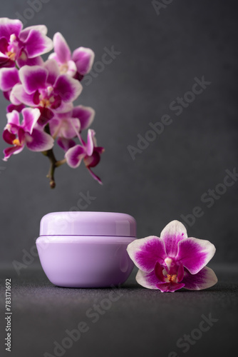 Lilac cosmetic cream jar  product mockup on dark background with orchid flower