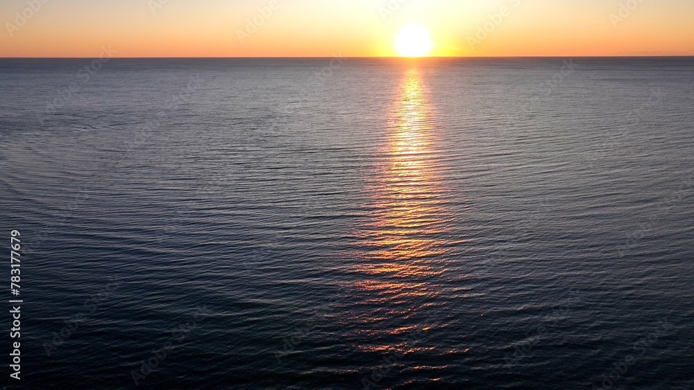 Beautiful morning sunrise over the ocean at the beach with warm sunlight shining on peaceful sea with calm gentle surf and waves at Pawleys Island, South Carolina low country lifestyle by the seashore Beautiful morning sunrise over the ocean at the beach with warm sunlight shining on peaceful sea with calm gentle surf and waves at Pawleys Island, South Carolina low country lifestyle by the seashore
