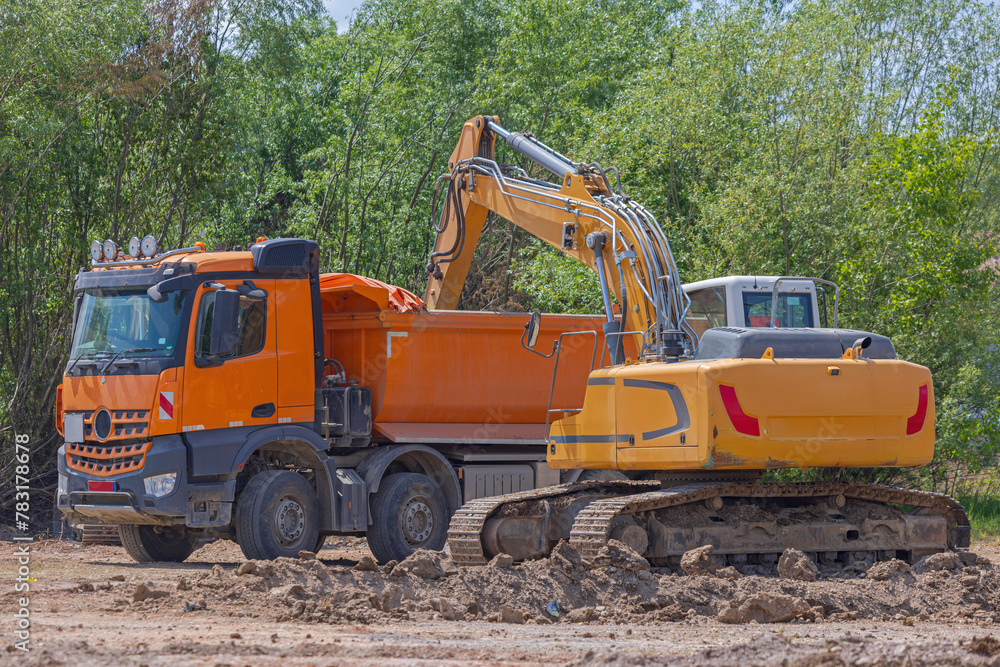 Tipper Truck Loading With Dirt With Excavator Machinery at Construction Site