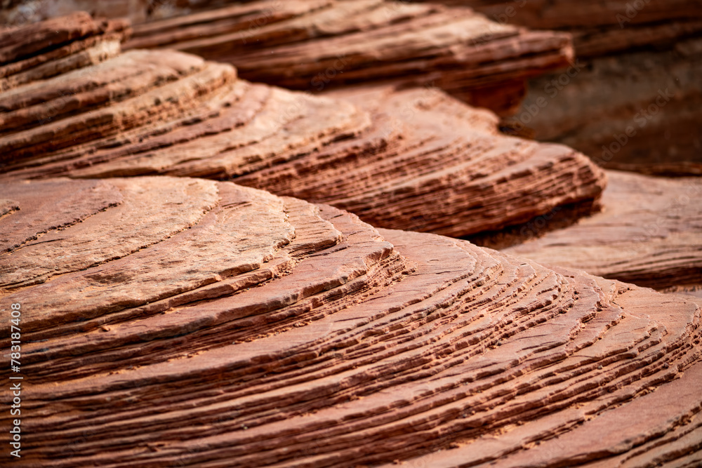 Layers of reddish sandstone with a sloping layer sequence and a rough ...