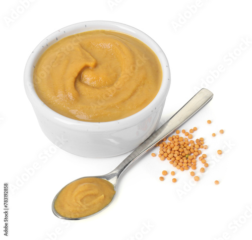 Fresh tasty mustard sauce in bowl and spoon with dry seeds isolated on white