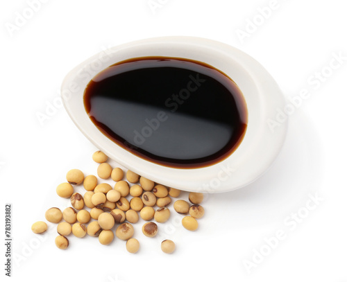 Tasty soy sauce in gravy boat and soybeans isolated on white, top view