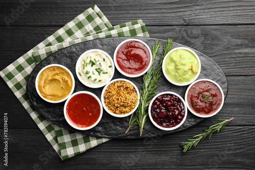Wallpaper Mural Different tasty sauces in bowls and rosemary on black wooden table, top view Torontodigital.ca