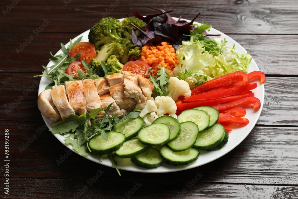 Balanced diet and healthy foods. Plate with different delicious products on wooden table