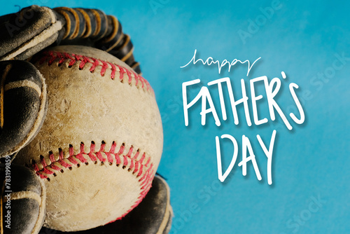 Happy Father's Day background with old baseball ball in glove on blue backdrop for holiday greeting.