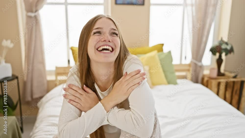 Laugh-covered young blonde woman wearing pyjama, covering mouth with hand, embarrassed at gossip in bedroom Laugh-covered young blonde woman wearing pyjama, covering mouth with hand, embarrassed at gossip in bedroom