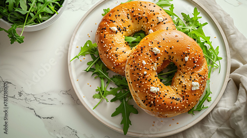 Fresh Bagels Sandwiches with cream cheese, eggs and green on white plate for delicious breakfast on a light background. Concept of tasty food.