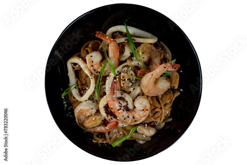 Asian wok noodles with with seafood and vegetables with chopsticks on the table.