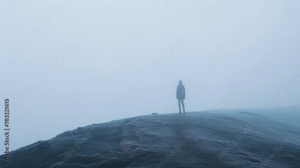 Fototapeta premium young man stands alone by the lake. Early cloudy foggy morning. To be alone with yourself