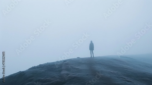 young man stands alone by the lake. Early cloudy foggy morning. To be alone with yourself