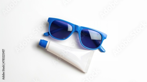 Sunglasses and sunblock tube with cream on white background