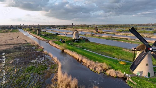 Aerial View to the wooden windmills at sunset in the Netherlands village of Kinderdijk. The beautiful Dutch canals are filled with water. Unesco World Heritage. Reflection. Holland, Europe from above photo