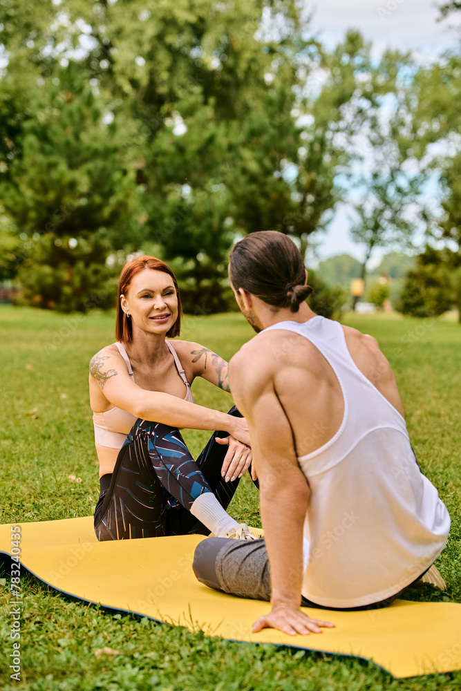 A woman in sportswear on a mat, guided by a personal trainer, showcasing determination and motivation.