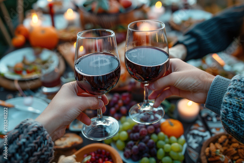 Cozy autumn evening with friends toasting with red wine glasses.