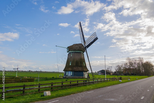 A typical Dutch windmill as a polder mill with paddle wheel for draining the polders in the Netherlands near the town of Schagen