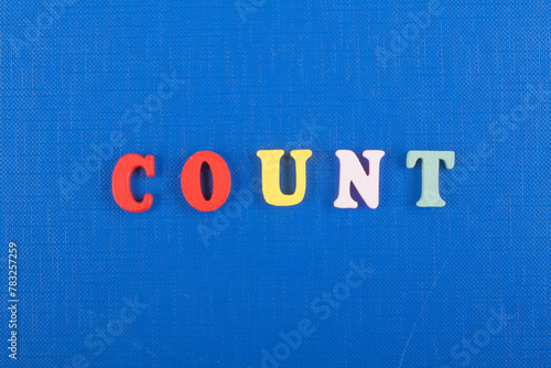 COUNT word on blue background composed from colorful abc alphabet block wooden letters, copy space for ad text. Learning english concept.