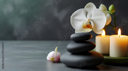 Zen stones, candles and white orchid flower on green and grey background with copy space, massage, spa and body care concept, flower