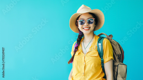 Young Asian tourist exudes joy in beach attire with hat and sunglasses.