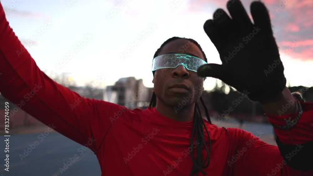 A close-up of an athlete in red, stretching with innovative eyewear during track training at dusk. A close-up of an athlete in red, stretching with innovative eyewear during track training at dusk. A close-up of an athlete in red, stretching with innovative eyewear during track training at dusk. A close-up of an athlete in red, stretching with innovative eyewear during track training at dusk.