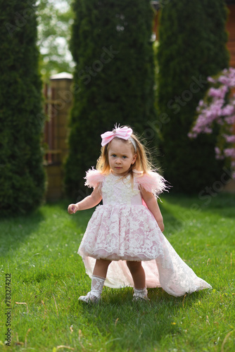 little girl in pink dress. little girl with pink flowers. little girl walking in the park