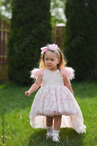 little girl in pink dress. little girl with pink flowers. little girl walking in the park