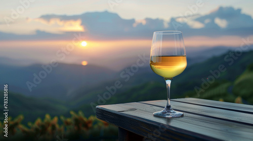 glass of white wine on a wooden table with a mountain