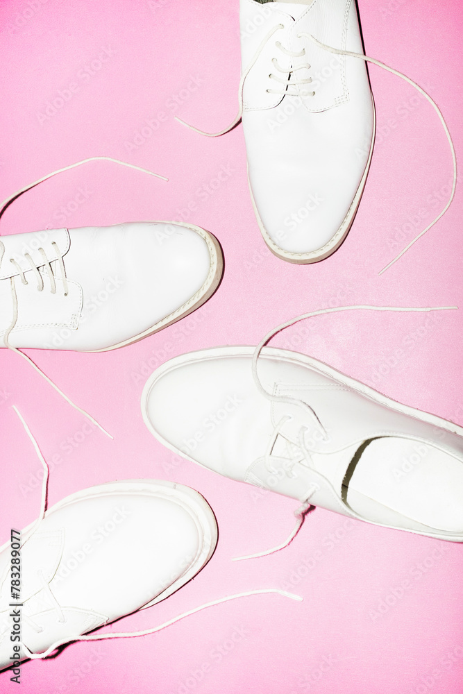Classic white lace shoes/footwear on a pink background and flashlight Classic white lace shoes/footwear on a pink background and flashlight