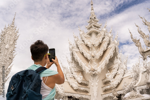 Tourist photographing Wat Rong Khun temple. photo