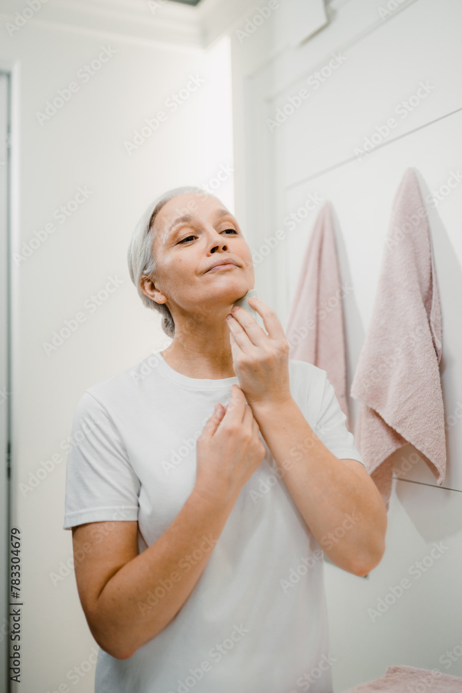 A woman does a facial massage A woman does a facial massage