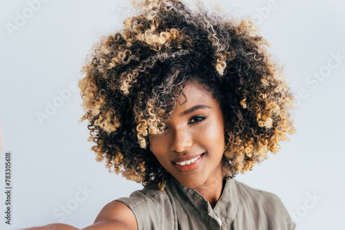 Vibrant afro young woman with curly hair smiling photo
