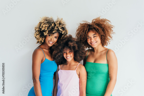 Three smiling women with curly afro hair posing together photo