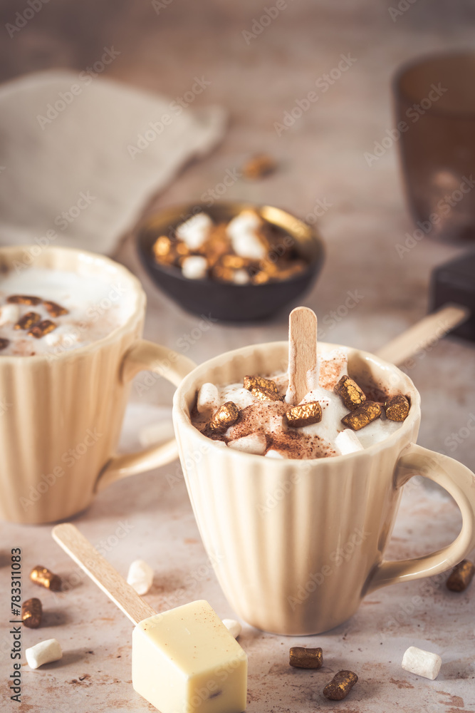 Two cups with hot chocolate dipping sticks and marshmallows
