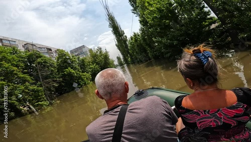 Volunteers evacuating people on boat after detonation of Kakhovka Hydroelectric Power Station. Flooding in Kherson town as a result of explosion of dam on Dnipro river in city of Novaya Kakhovka photo