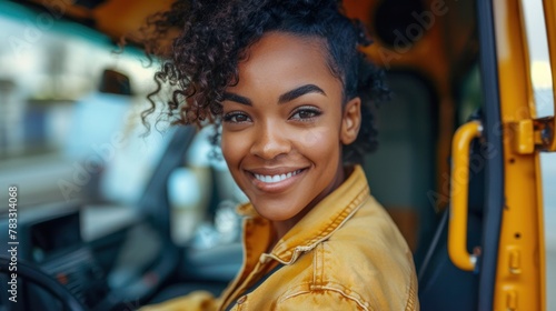 Happy black woman delivery driver driving delivery truck and looking at camera