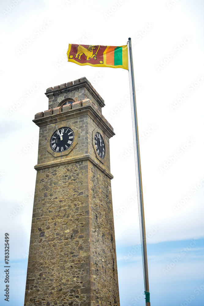 Galle Clock Tower and the Sri Lankan national flag that waving in Galle Fort, Galle, Sri Lanka.