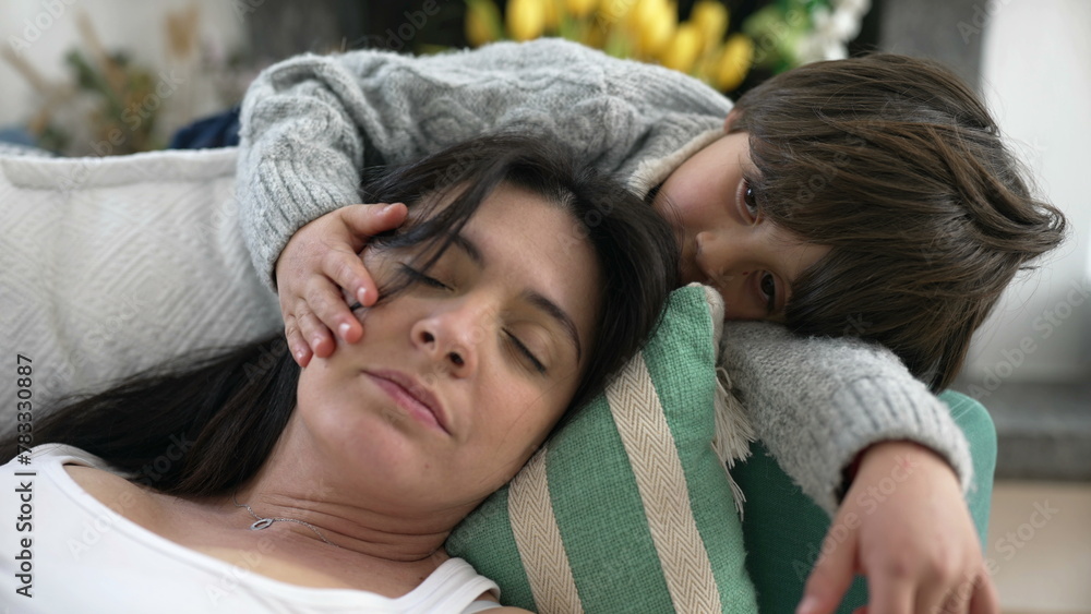 Son caresses mother while she rests laid on couch at home. Tender family relationship bond. Parent Resting on Couch with Son Lying Beside Her, Displaying Care and Affection Son caresses mother while she rests laid on couch at home. Tender family relationship bond. Parent Resting on Couch with Son Lying Beside Her, Displaying Care and Affection
