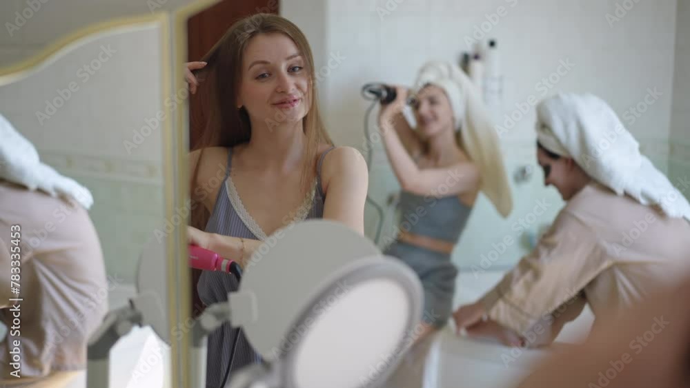 Girls have fun and have fun doing makeup and hairstyles in the bathroom. The girls are happy and laughing Girls have fun and have fun doing makeup and hairstyles in the bathroom. The girls are happy and laughing
