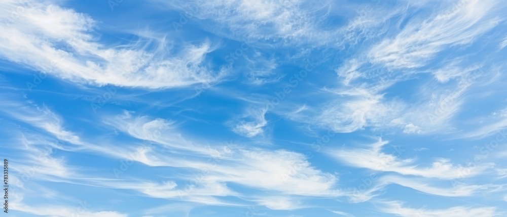   A blue sky dotted with white clouds, a plane in the foreground passes by
