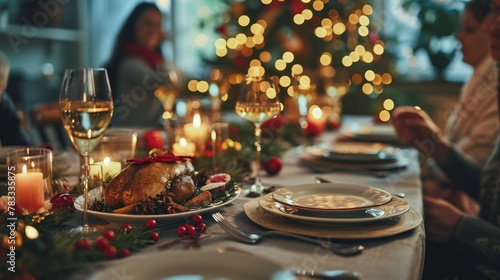 A Christmas dinner table with a roasted turkey, candles, wine glasses, and a Christmas tree in the background. © ProPhotos