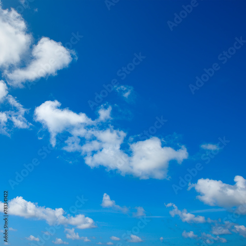 White fluffy clouds and bright sun on blue sky.