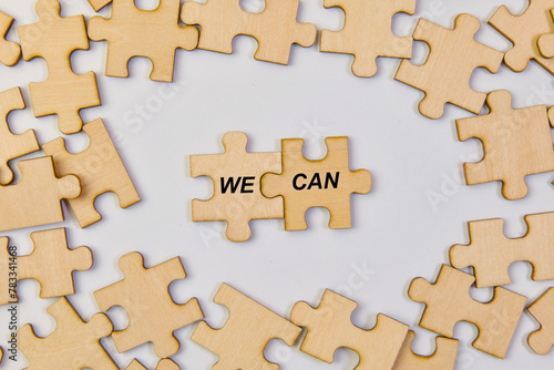Wooden puzzle pieces with word we can Business concept image