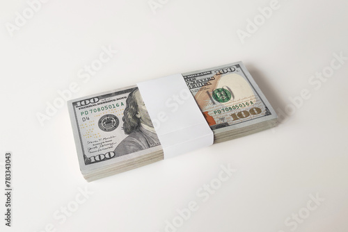 One hundred dollars bills. A ten thousand dollar bundle of new $100 bills on a white background.