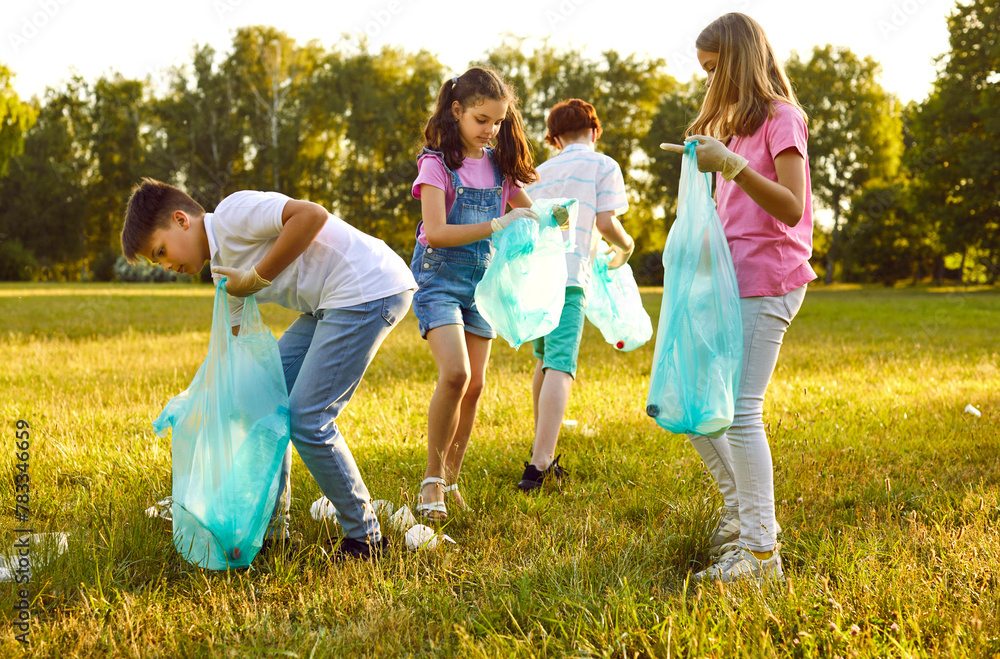 Fototapeta premium Group of teenage children volunteers with gloves and trash bags collecting garbage in the summer park outdoors. Kids boys and girls cleaning environmental pollution. Ecology concept.
