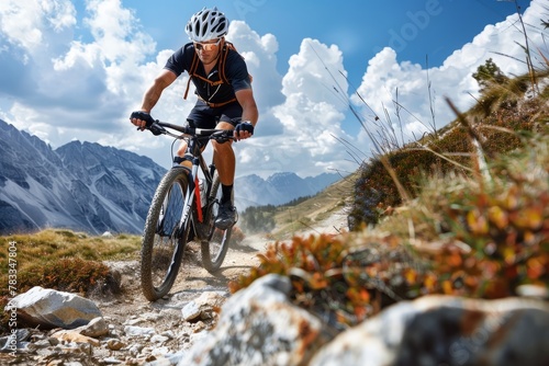 A man in action, riding a mountain bike along a challenging rocky trail in the wilderness photo