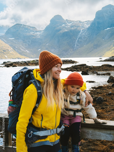 Mother and child traveling in Lofoten islands family vacations in Norway adventure healthy lifestyle outdoor, parent and kid backpacking together © EVERST
