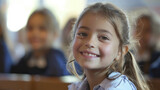 A primary school girl smiles brightly in her classroom, radiating happiness.